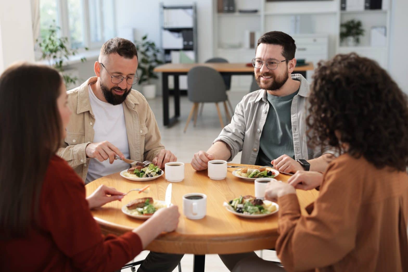 4 people sitting at a table eating