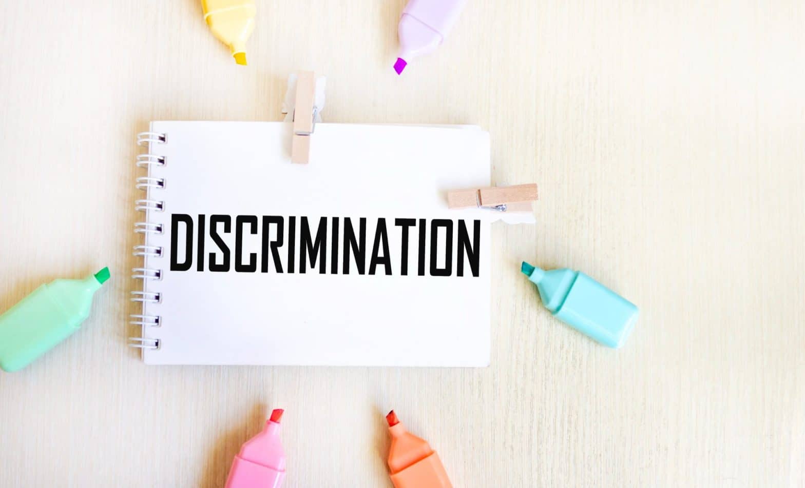 Highlighters surrounding a piece of paper that says discrimination
